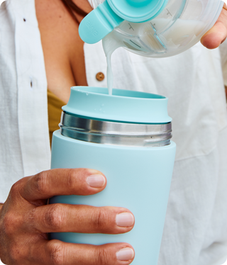Person pouring breast milk from a breast pump cup into an Elvie breast milk cooler.