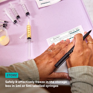A person labelling their colostrum syringe