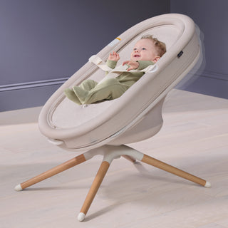 Baby in a modern Elvie Rise smart bouncer with a neutral color scheme