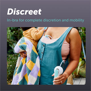 A woman holds her baby in her garden whilst pumping using the Elvie Wave manual breast pump